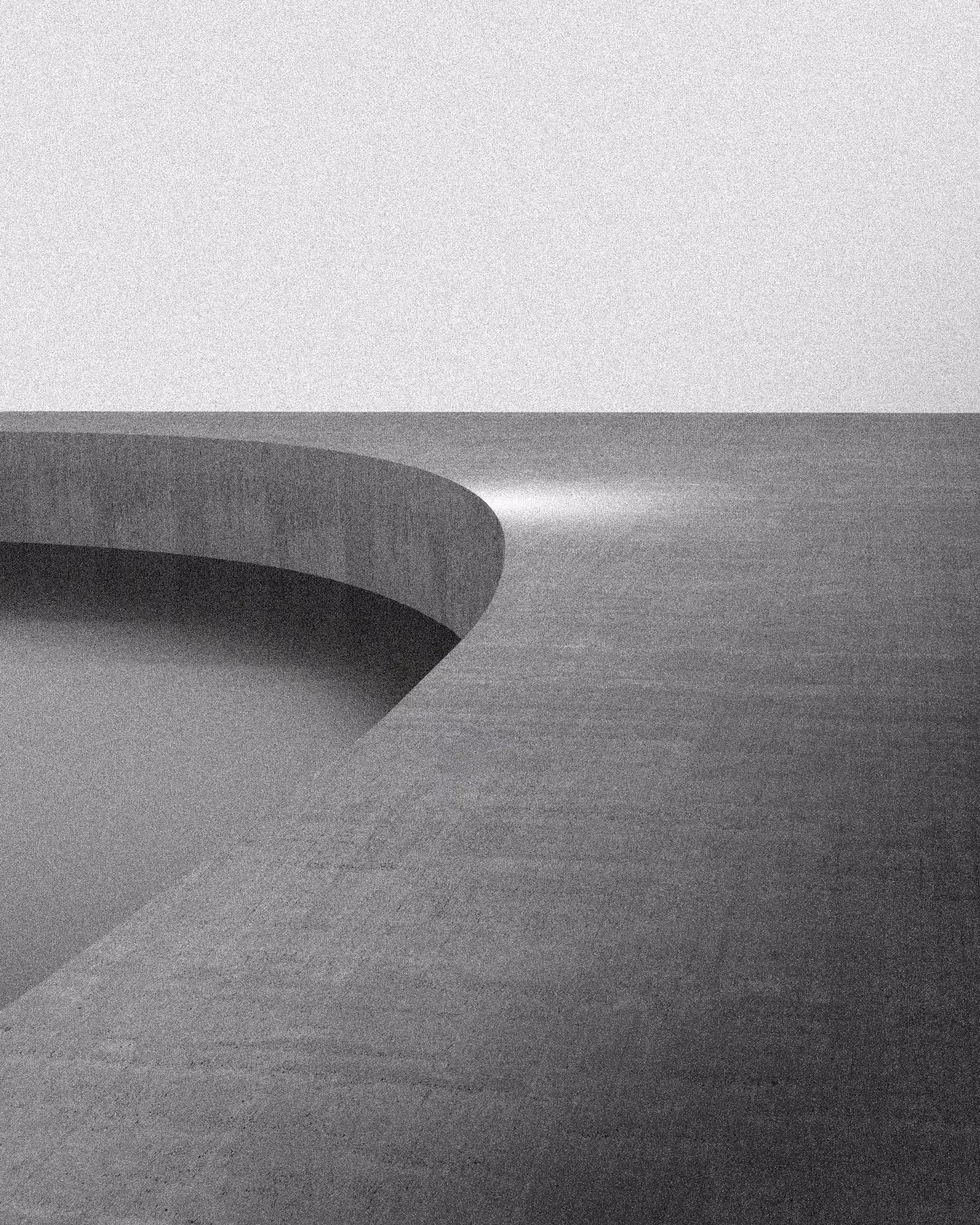 The curved end of a concrete wall sweeps across a grey plain beneath a pale sky, a soft light on the ground where it ends.